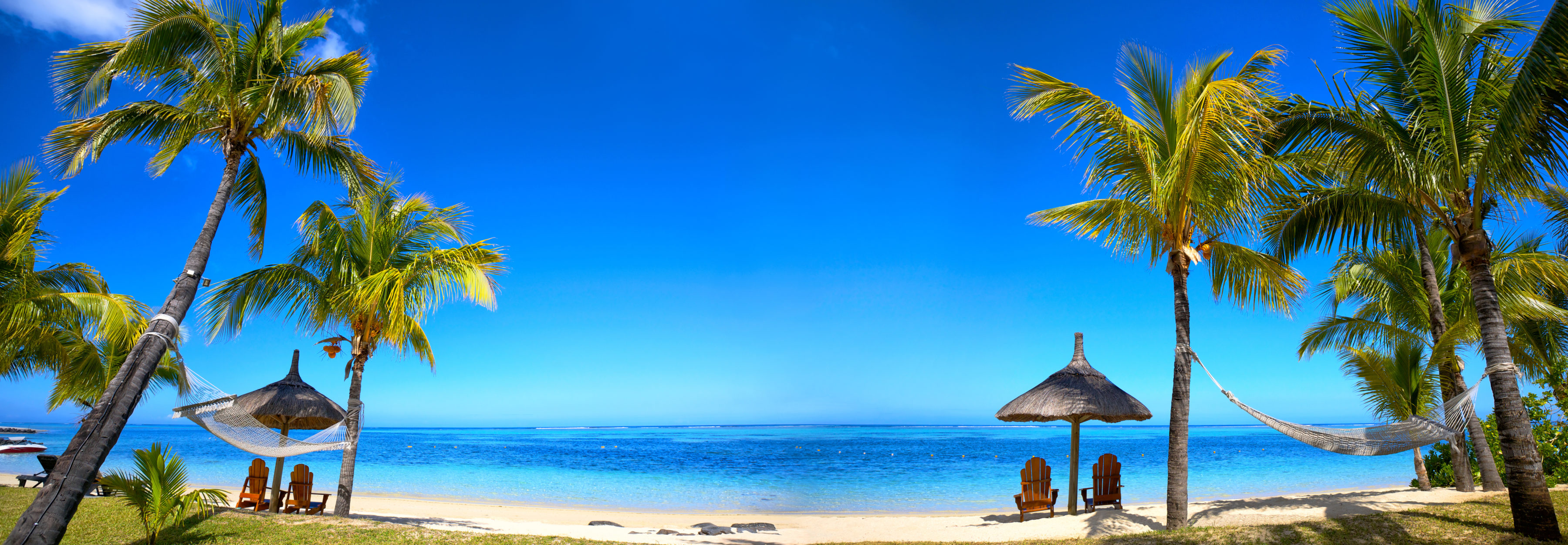 Tropical beach panorama with chairs and umbrellas