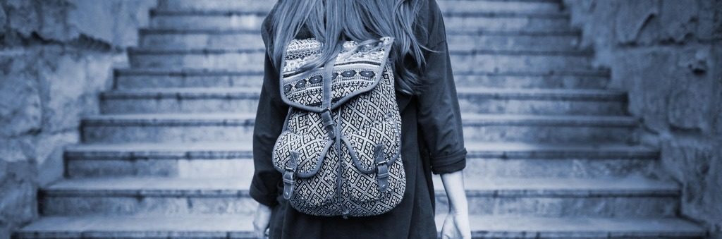 Student girl with a backpack climbing stairs