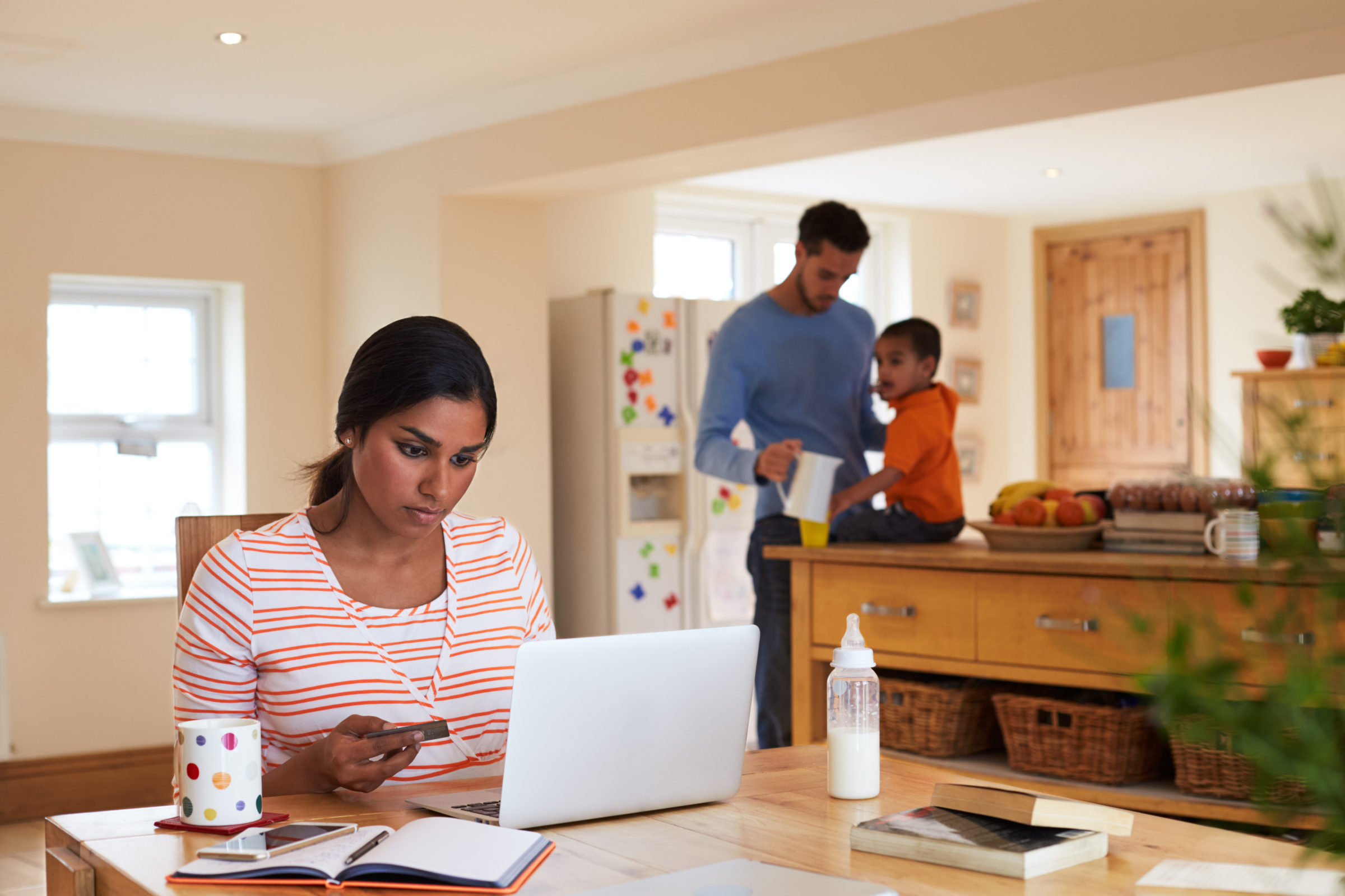 Family In Kitchen With Mother Making On Line Purchase