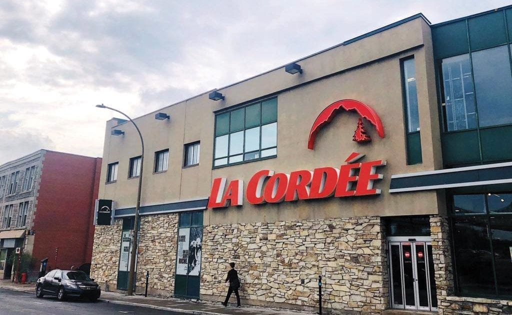 Une personne marche devant une boutique La Cordée