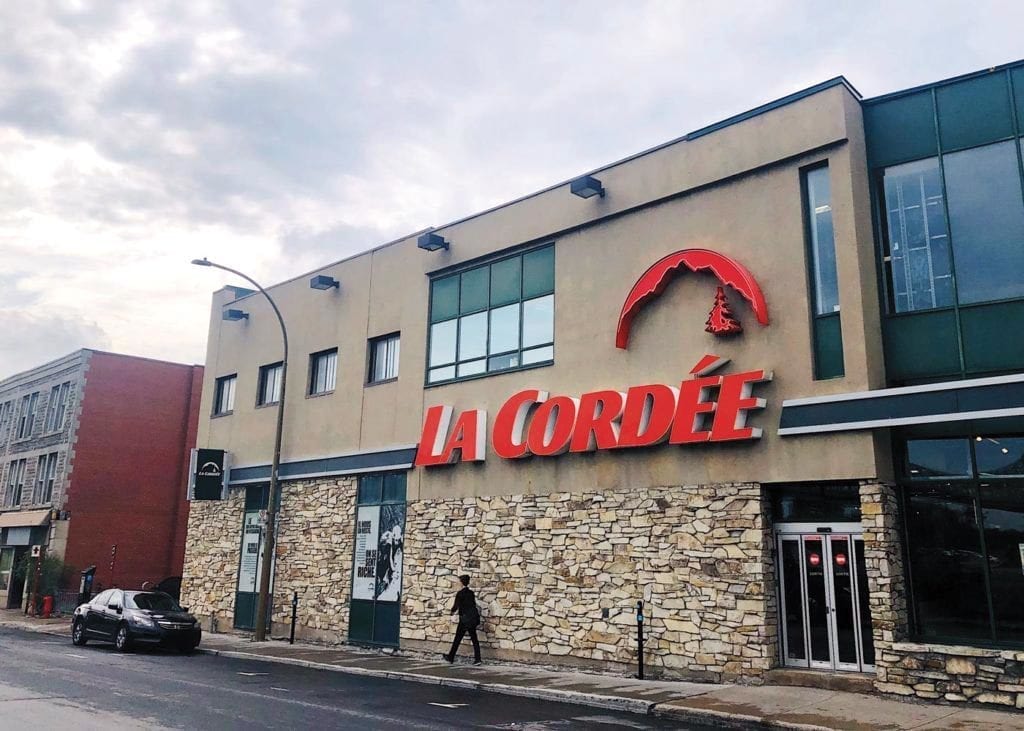 Une personne marche devant une boutique La Cordée