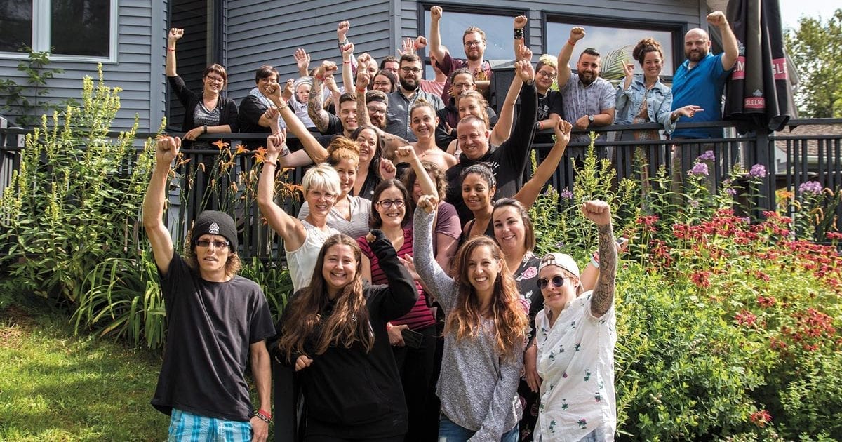 Photo des militantes et militants de l'École de la relève, à l'extérieur d'un bâtiment avec les poings en l'air