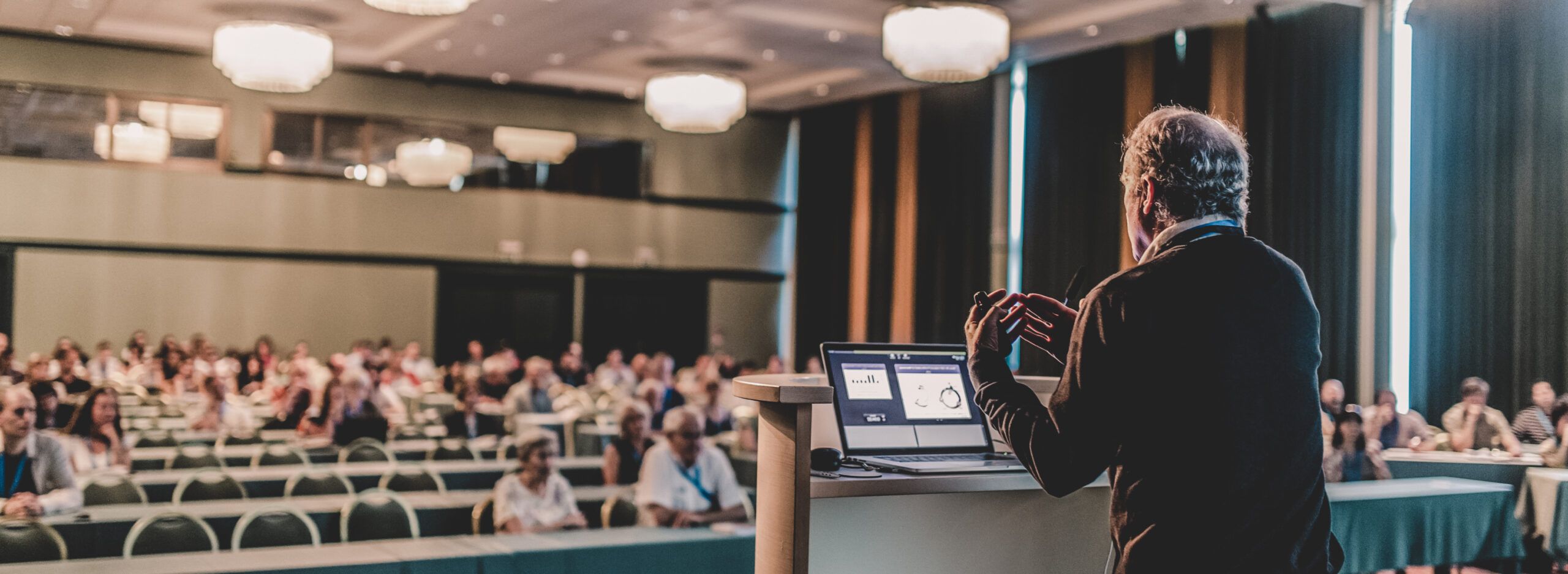 Senior public speaker giving talk at scientific conference.