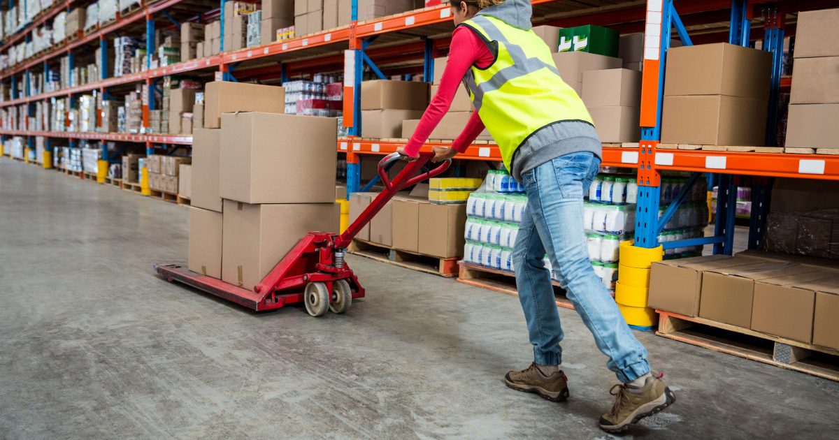 Worker pushing trolley with boxes