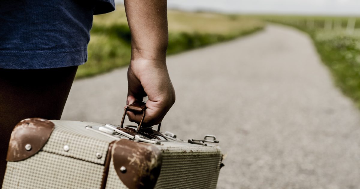 Refugee child goes on the road with her  suitcase