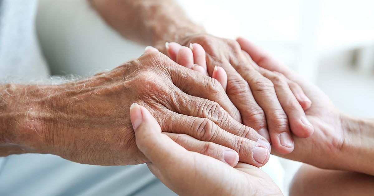 Young woman holding senior man hands, closeup