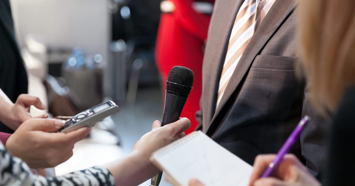 Journalist holding microphone conducting media interview