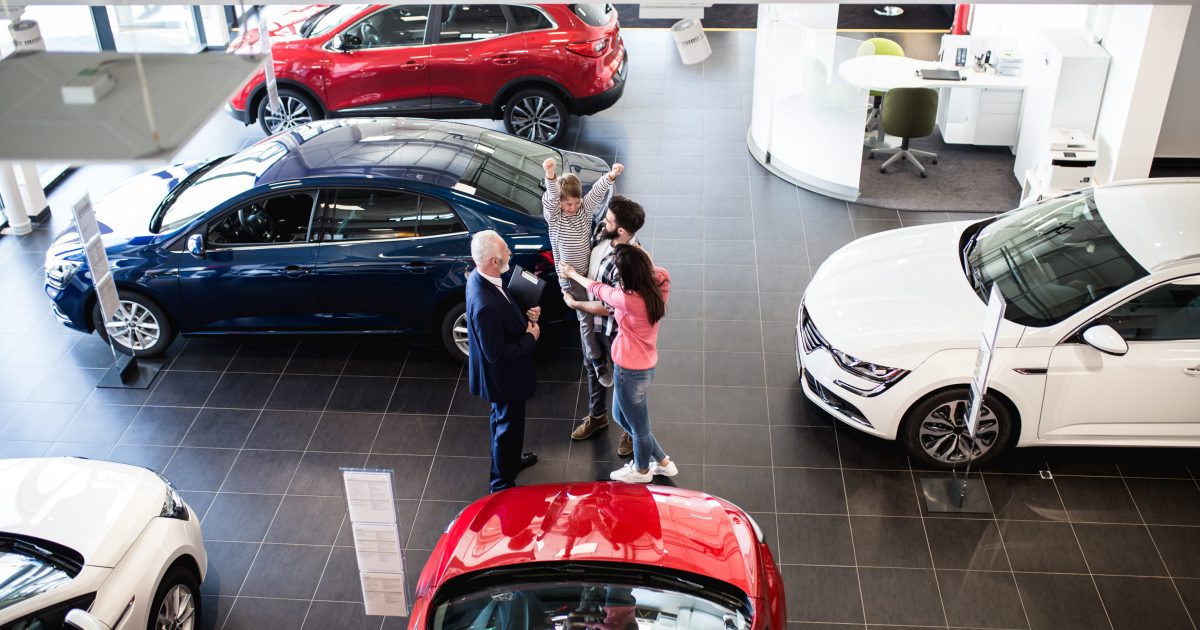 Happy family buying a new car at the car showroom.