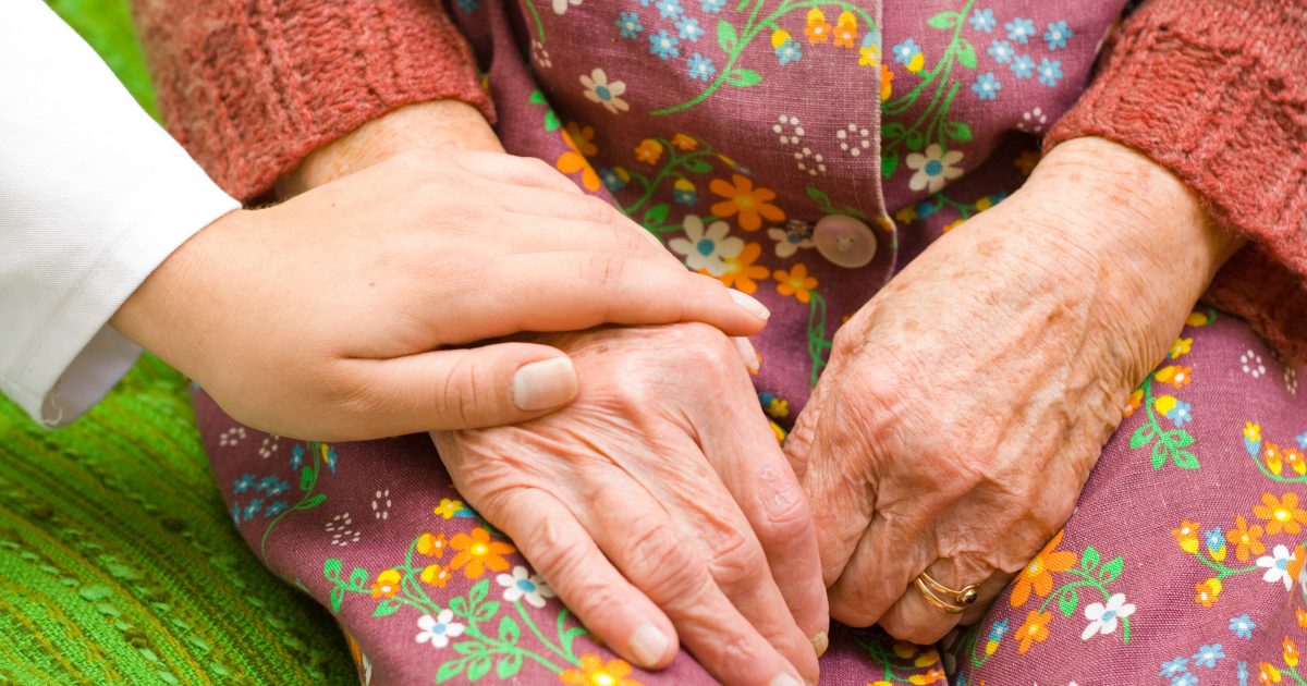 A doctor holding an old woman's hand - part of a series.